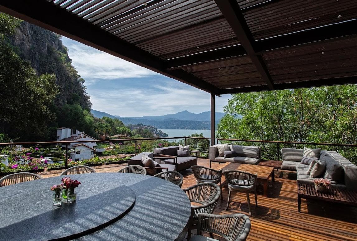 Terraza cubierta con comedor y lounge, vista al lago y montañas