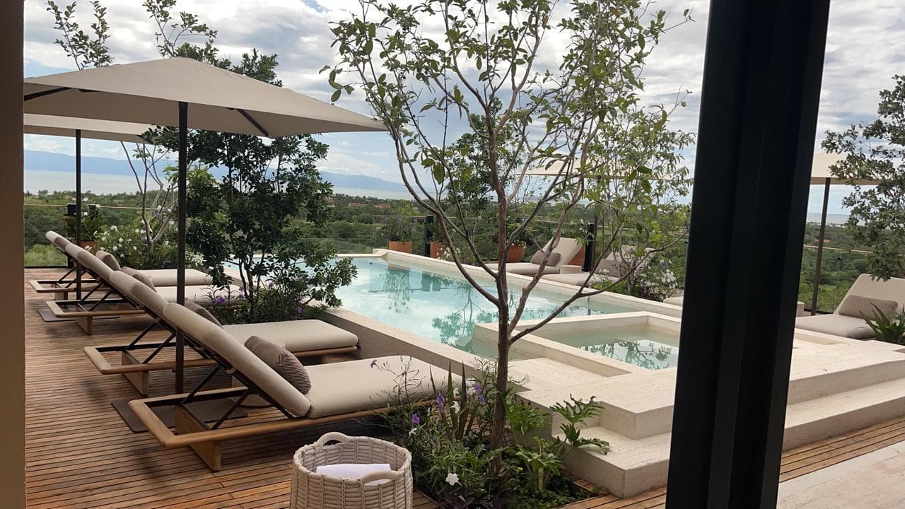 Alberca con jacuzzi integrado, tumbonas y vista a la Bahía de Banderas
