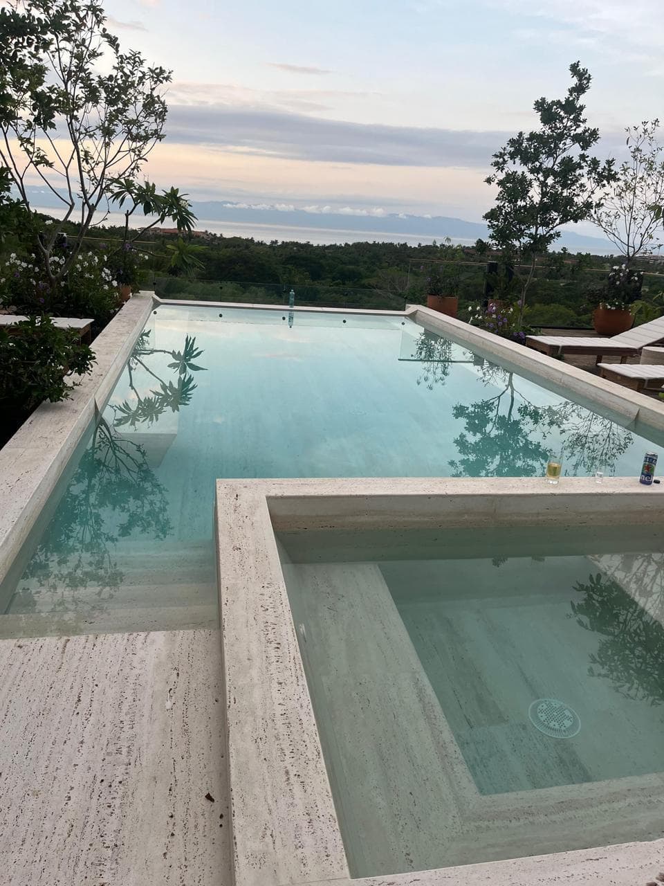 Alberca y jacuzzi al atardecer con horizonte sobre el Pacífico